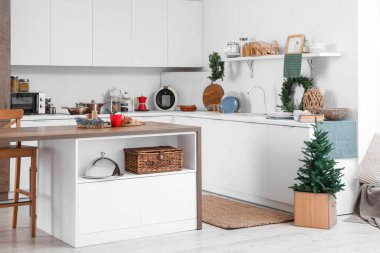 Beyaz tezgahlı, Noel süslemeli ve köknar ağacı olan festival mutfağı.