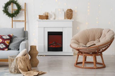 Gri kanepesi, koltuğu, Noel süslemeleri ve parıldayan ışıklarıyla şenlikli oturma odasının içinde.