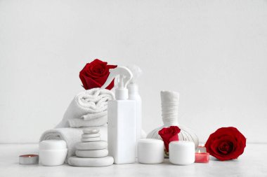 Kırmızı gül çiçekli spa kompozisyonu ve ışık arka planında yanan mumlar. Sevgililer Günü kutlaması