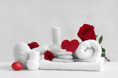 Hafif arka planda spa aksesuarları, kozmetik ürünleri ve gül çiçekleri olan bir kompozisyon. Sevgililer Günü kutlaması