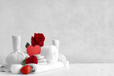 Hafif arka planda spa aksesuarları, kozmetik ürünleri ve gül çiçekleri olan bir kompozisyon. Sevgililer Günü kutlaması