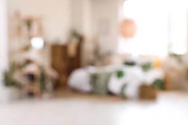 Yeşil bitkiler ve raf üniteleriyle aydınlık yatak odasının bulanık görüntüsü