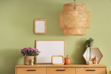 Dekor ve kasımpatı çiçekli çekmeceler yeşil duvarın yanında. Yakın çekim.