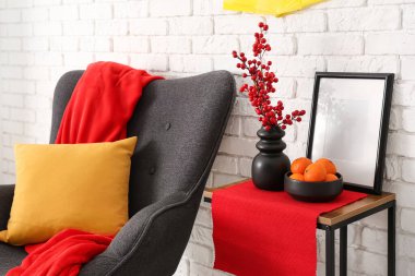 Çin Yeni Yılı için dekore edilmiş oturma odasının içinde koltuk ve masa var.