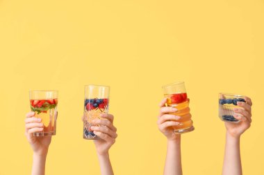 Sarı zemin üzerinde aşılanmış su olan birçok el