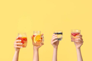 Sarı zemin üzerinde aşılanmış su olan birçok el