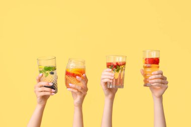 Sarı zemin üzerinde aşılanmış su olan birçok el