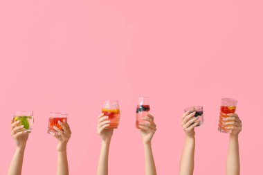 Pembe arka planda erimiş su olan birçok el