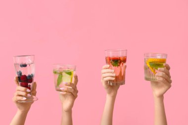 Pembe arka planda erimiş su olan birçok el