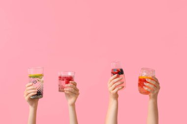 Pembe arka planda erimiş su olan birçok el