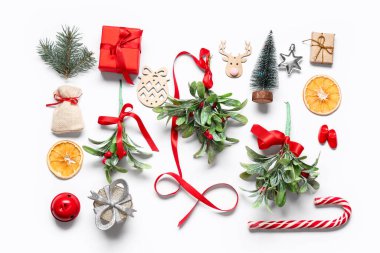 Güzel Noel süslemeleri ve beyaz arka planda ökseotu dalları olan kompozisyon