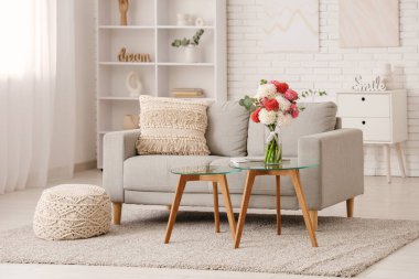 Aydınlık oturma odasının içinde çok güzel yıldız çiçekleri olan vazo.