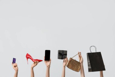 Hediye kutusu, kredi kartı, cep telefonu ve gri arka planda aksesuarları olan kadın elleri. Kara Cuma İndirimi