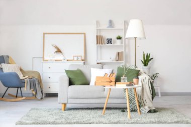 Oturma odasının içinde kitaplar olan rahat bir kanepe ve kahve masası.