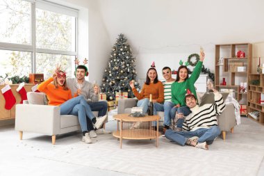 Evde yeni yılı kutlamak için şampanya içen bir grup genç.