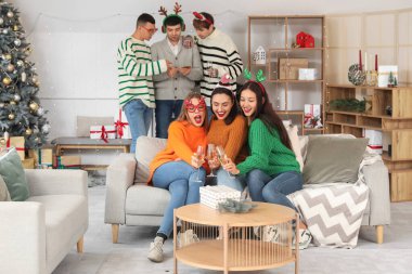 Şampanyalı genç kadınlar yeni yılı ev partisinde kutluyor.