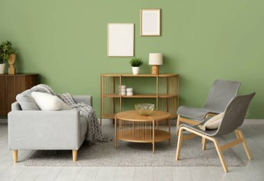 Oturma odasında kahve masası ve sandalyeleri olan rahat gri kanepe.