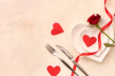 Kırmızı gül ve beyaz arka planda kağıt kalplerle güzel bir masa. Sevgililer Günü kutlaması