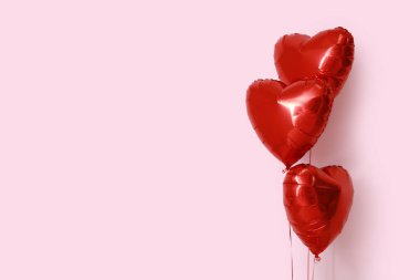 Pembe arka planda kalp şeklinde hava balonları. Sevgililer Günü kutlaması