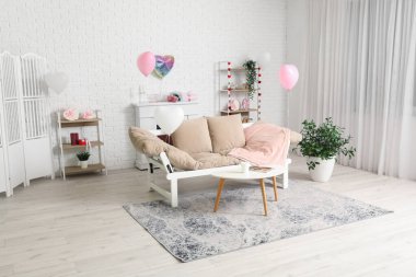 Sevgililer Günü kutlamaları için rahat kanepesi ve süslemeleri olan modern oturma odasının içinde.