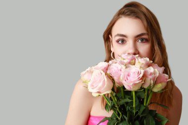 Hafif arka planda gülleri olan genç bir kadın, yakın plan. Sevgililer Günü kutlaması