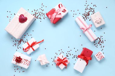 Farklı hediye kutularından yapılmış çerçeve ve renk arkaplanındaki pullar. Sevgililer Günü kutlaması