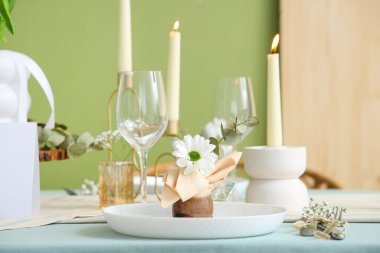 Yeşil duvarın yanındaki Uluslararası Kadınlar Günü kutlamaları için yanan mumlarla dolu güzel bir masa.