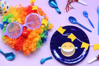 Palyaço peruğu, komik gözlükler ve leylak arkaplanda 1 Nisan için parti dekorasyonu.