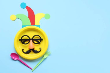 Mavi arkaplanda 1 Nisan şakası için komik gözlükler ve kağıt palyaço şapkası ile masa ayarları