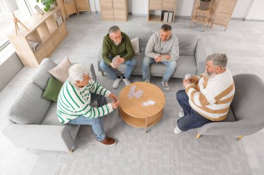 Evde kart oynayan yaşlı adamlar