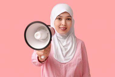 Pembe arka planda megafonu olan genç Asyalı Müslüman kadın. Ulusal Duyulma Günü