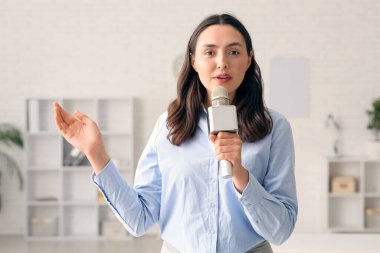 Female reporter with microphone in studio