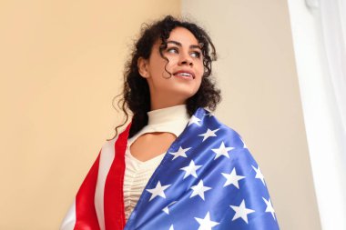 Evinde Amerikan bayrağı taşıyan güzel, mutlu, Afro-Amerikan kadın.
