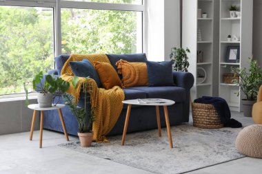 Oturma odasındaki kahve masasının yanında ekoseli rahat bir kanepe.