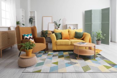 Oturma odasının içinde rahat bir kanepe, koltuk ve kahve masası.