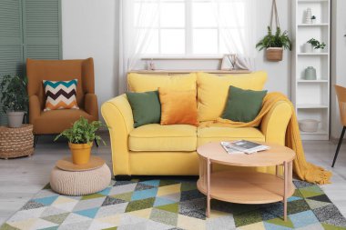 Oturma odasının iç tarafında rahat bir kanepe, kahve masası ve koltuk.