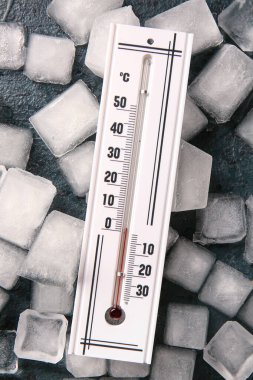 Koyu renk arka planda hava termometresi ve buz küpleri