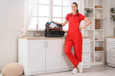 Mutfakta alet çantası olan kadın tesisatçı.