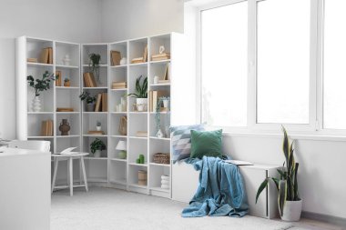 Kitaplık, yastık ve ekose modern oda içi.