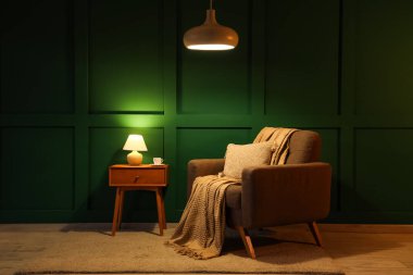 Geceleri parıldayan lambaları, koltuğu ve masası olan karanlık odanın içinde.