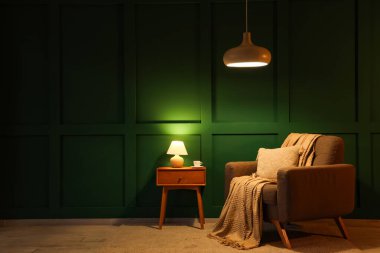 Geceleri parıldayan lambaları, koltuğu ve masası olan karanlık odanın içinde.