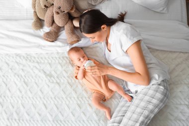 Anne, bebeğini sütle besliyor.