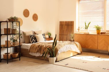 İçinde bitkiler, raf ünitesi ve tuvalet olan rahat bir yatak odası.