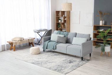 Oturma odasında kanepe, sentezleyici ve bank var.