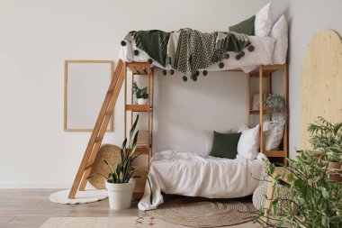 İçinde ranza ve bitkiler olan hafif çocuk odası.