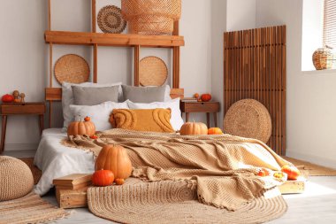 Sonbahar dekoru ve pufları olan rahat bir yatak odası.