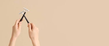 Bej arkaplandaki jiletleri tutan eller ve metin için boşluk