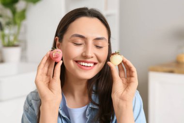 Çikolata kaplı çilekleri olan güzel genç bir kadın.