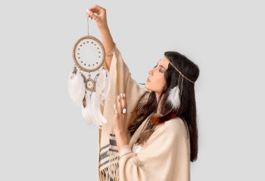 Işık arka planında rüya kapanı olan güzel bir kadın şaman.