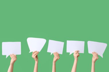 Yeşil arka planda konuşma baloncukları olan kadın eller